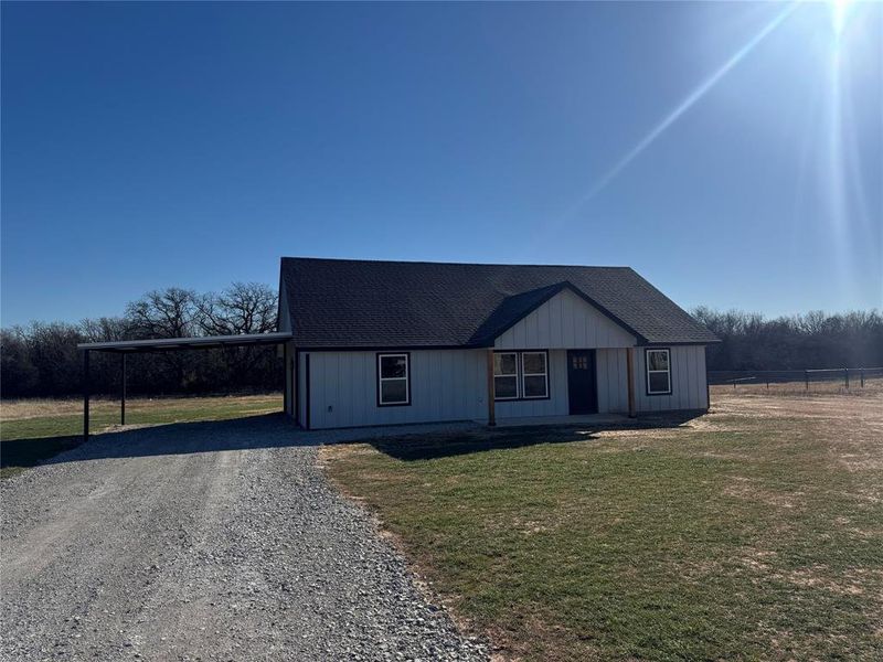 View of front of property with a front lawn and a carport