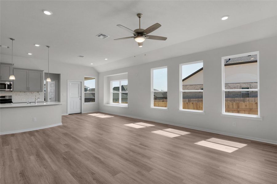 Unfurnished living room featuring dark wood finished floors, a ceiling fan, recessed lighting, and lofted ceiling