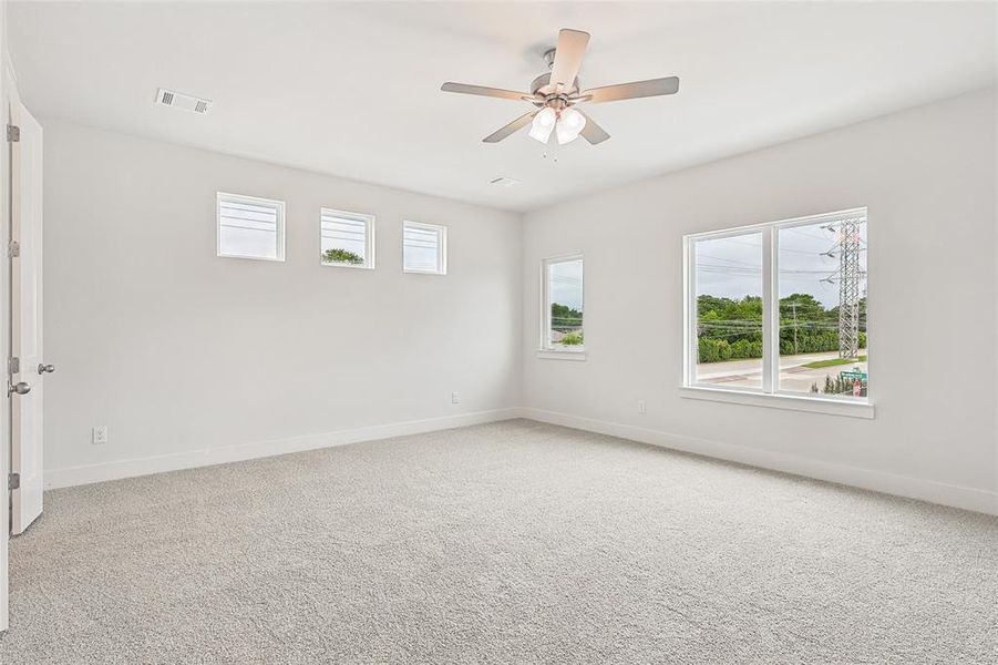 Unfurnished room featuring carpet floors and ceiling fan