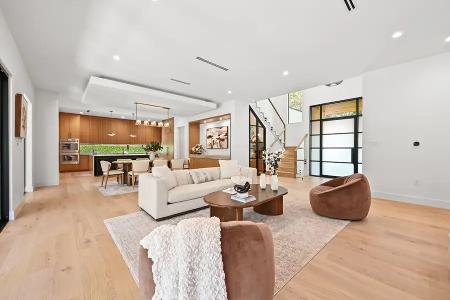 Living area with stairs, light wood-style floors, and recessed lighting