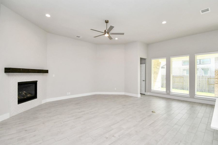 Family room flooded with natural light through the expansive windows. The premium tile flooring adds a touch of luxury to the space, creating the perfect setting for relaxing moments and cherished gatherings with loved ones. Family room flooded with natural light through the expansive windows. The premium tile flooring adds a touch of luxury to the space, creating the perfect setting for relaxing moments and cherished gatherings with loved ones.