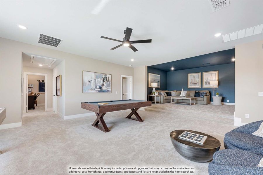 Spacious game room with pool table, carpet flooring, ceiling fan, and blue accent wall seating area