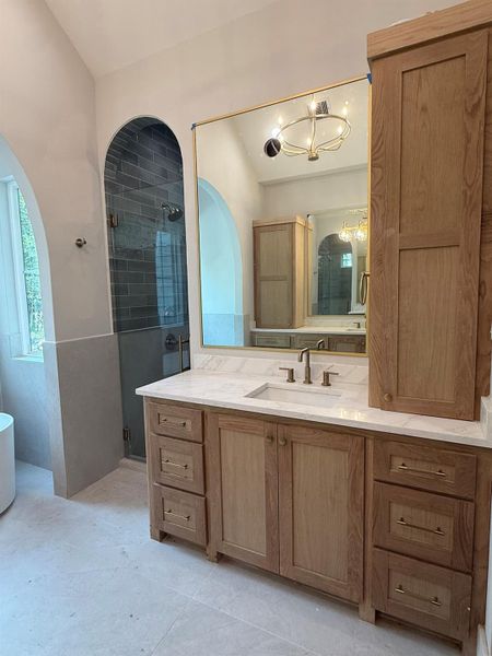 Bathroom featuring a stall shower, vanity, a freestanding bath, and a chandelier