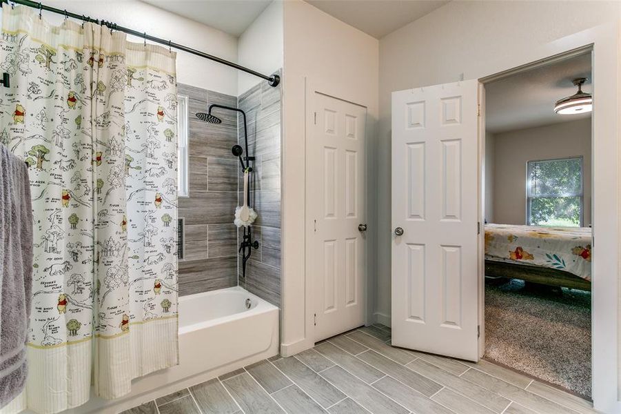 Ensuite bathroom with shower / tub combo and wood finish floors Ensuite bathroom with shower / tub combo and wood finish floors