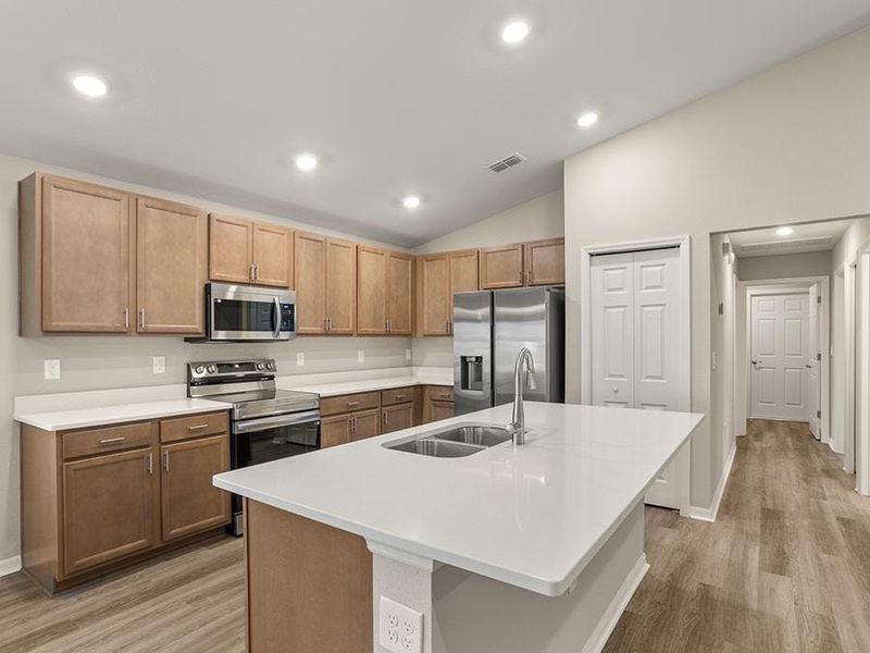 Your new kitchen includes a counter-height island, pantry, and ample cabinet spaceYour new kitchen includes a counter-height island, pantry, and your choice of finishes - Begonia by Highland Home