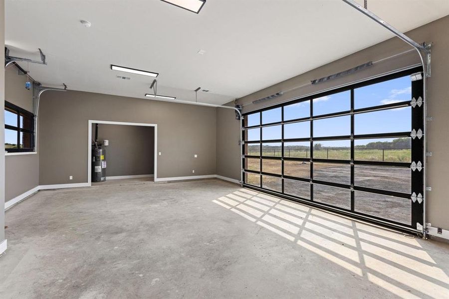 Garage featuring electric water heater and
baseboards Garage featuring electric water heater and
baseboards