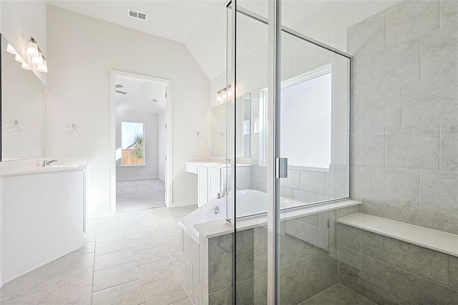 Bathroom featuring tile patterned floors, vanity, independent shower and bath, and lofted ceiling