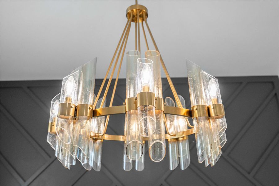 A striking brass chandelier with artful glass tubes illuminates this space, creating a warm, inviting glow. A striking brass chandelier with artful glass tubes illuminates this space, creating a warm, inviting glow.