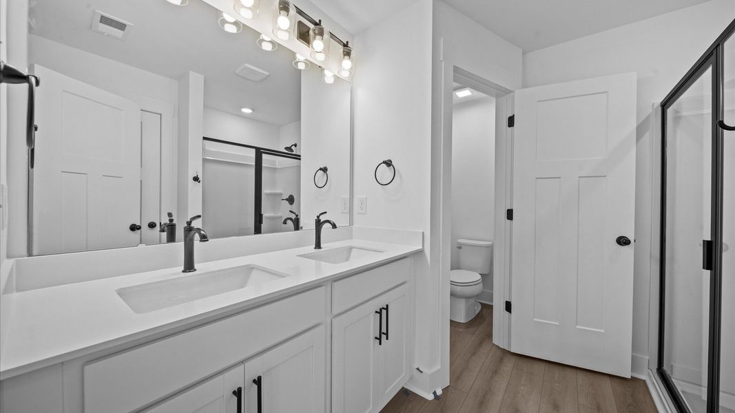 First-rate primary bathroom offering an elegant tiled walk-in shower and dual sinks with superior style