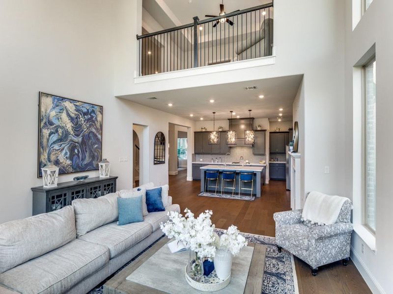 Living area featuring dark wood-type flooring, a towering ceiling, and a ceiling fan