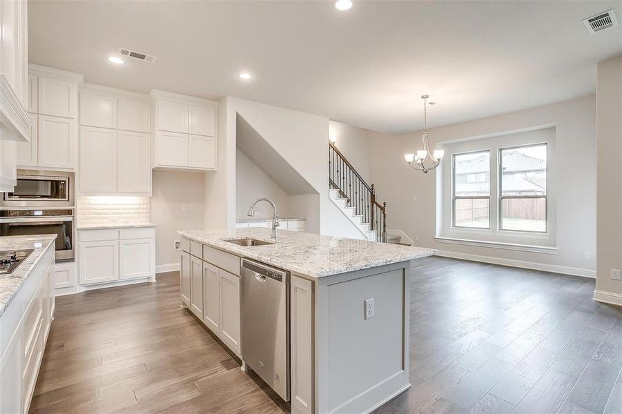 Kitchen featuring white cabinetry, a kitchen island with sink, light hardwood / wood-style floors, appliances with stainless steel finishes, and sink