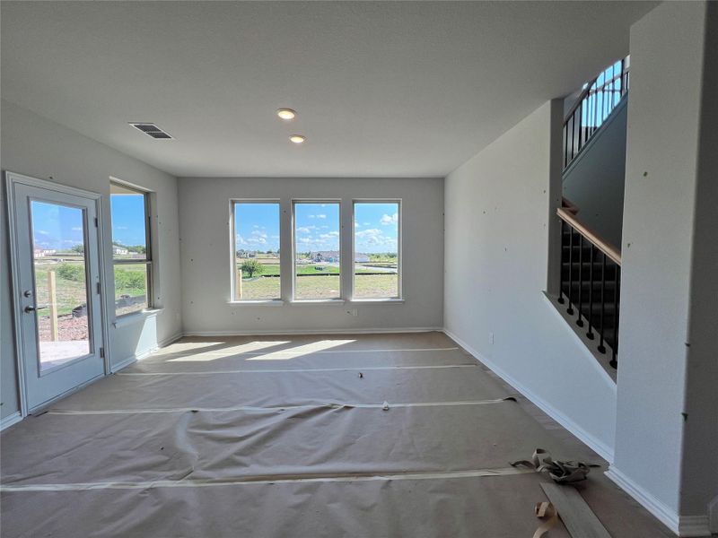 Unfurnished living room featuring stairs and recessed lighting