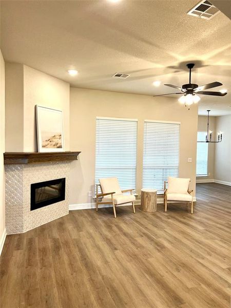 Sitting room featuring wood finished floors, a tile fireplace, baseboards, ceiling fan, and recessed lighting Sitting room featuring wood finished floors, a tile fireplace, baseboards, ceiling fan, and recessed lighting