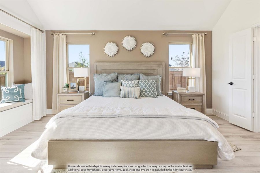 Master bedroom with king bed, light wood floors, window seat, and two windows flanking a tan accent wall Master bedroom with king bed, light wood floors, window seat, and two windows flanking a tan accent wall