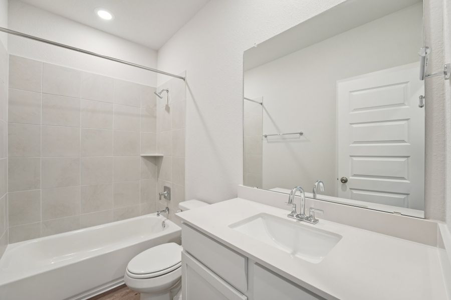 A bathroom with a tub sink and toilet.