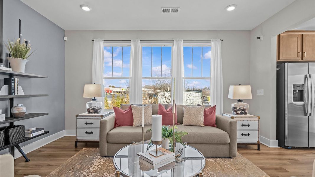 Eye-catching family room with elegant millwork and seamless access to dining and kitchen at Brookland Place