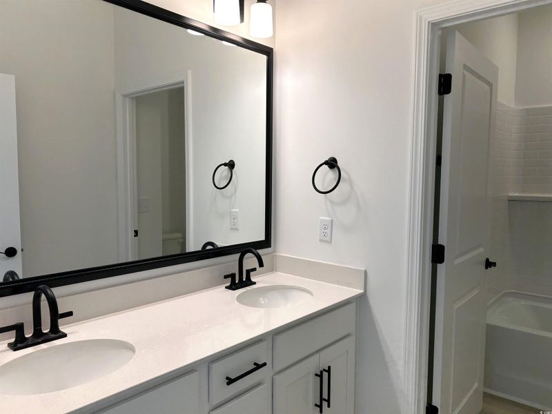 Full bathroom with double vanity and bathtub / shower combination
