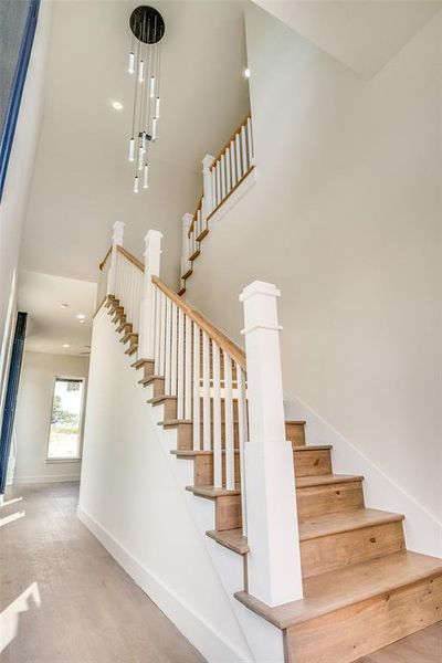 Stairway featuring a high ceiling and baseboards