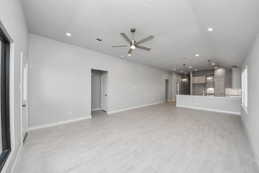 Relax and unwind in this inviting family room, illuminated by abundant natural light streaming in through tall windows, complemented by high ceilings and stunning flooring. Stay comfortable year-round with the gentle breeze from the ceiling fan, creating the perfect atmosphere for family gatherings. Sample photo of completed home with similar floor plan. Actual colors and selections may vary.