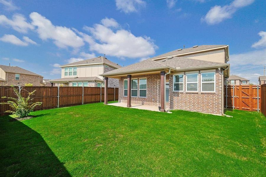 Back of property with a yard and a patio