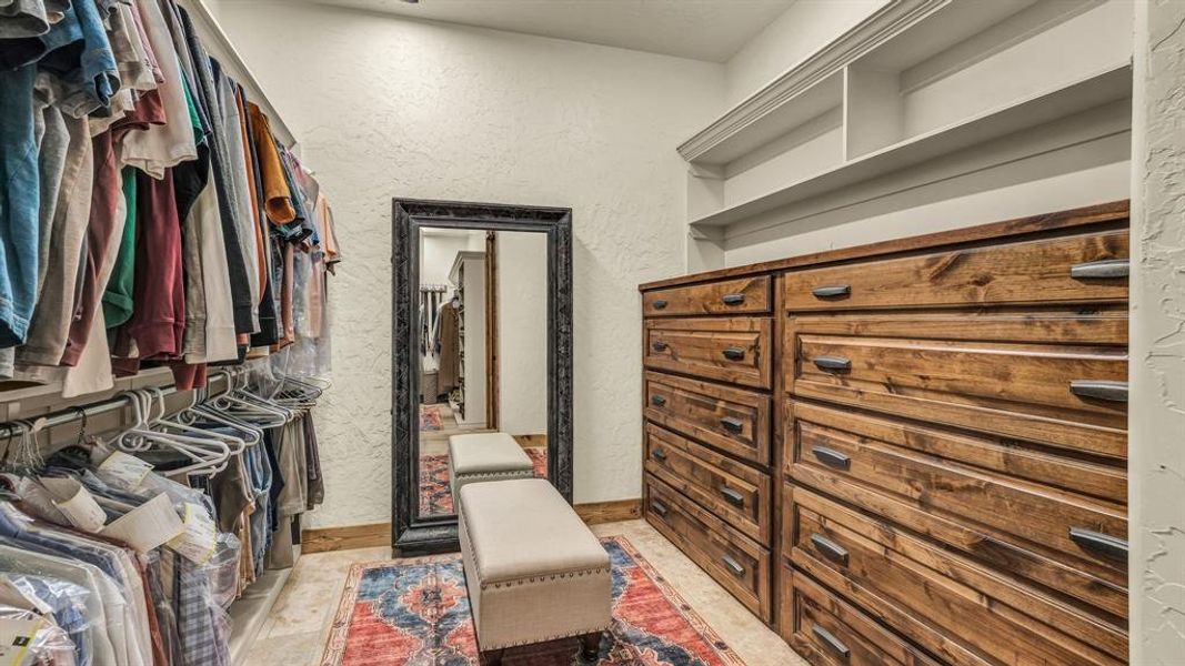Custom built-ins, ample hanging space, and a full-length mirror create a spacious and organized dressing area.