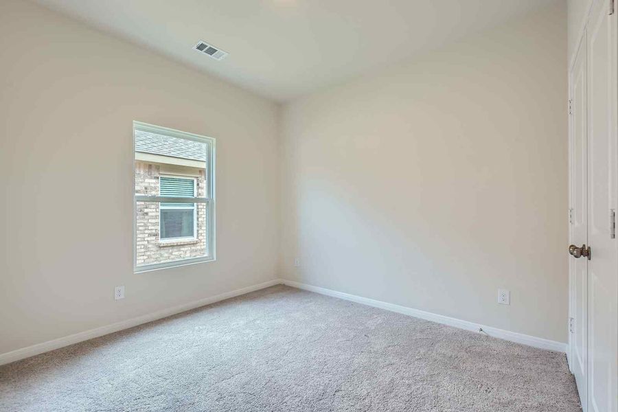 A room with a window and a carpet.