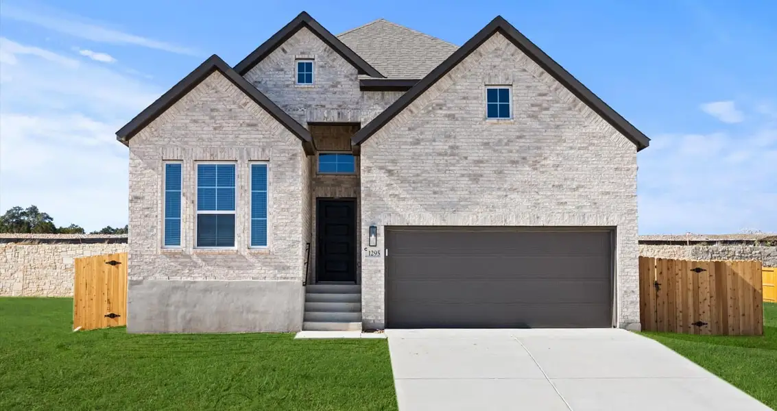 Front exterior of a new home in Meyer Ranch, New Braunfels, TX, highlighting curb appeal (Image 1).