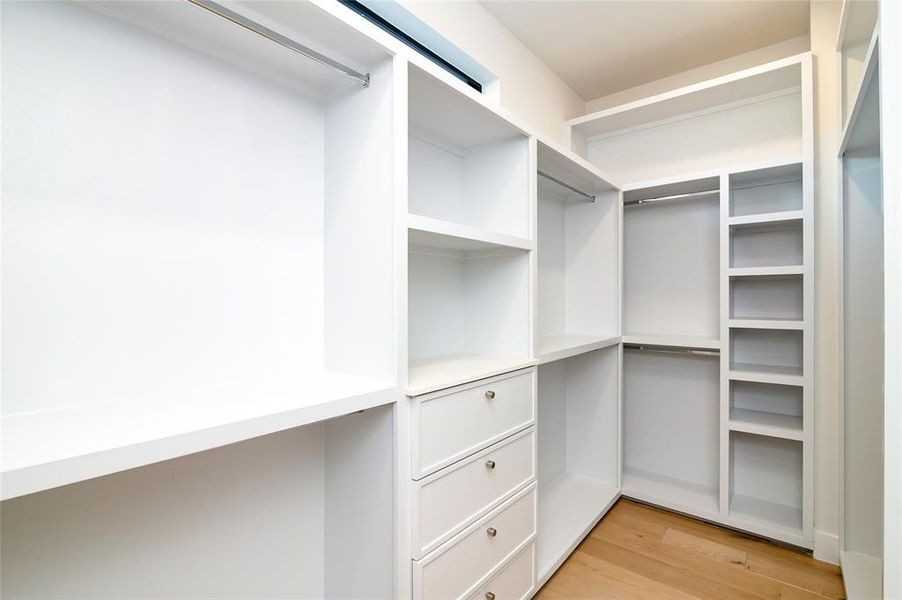 Spacious closet with light hardwood / wood-style flooring