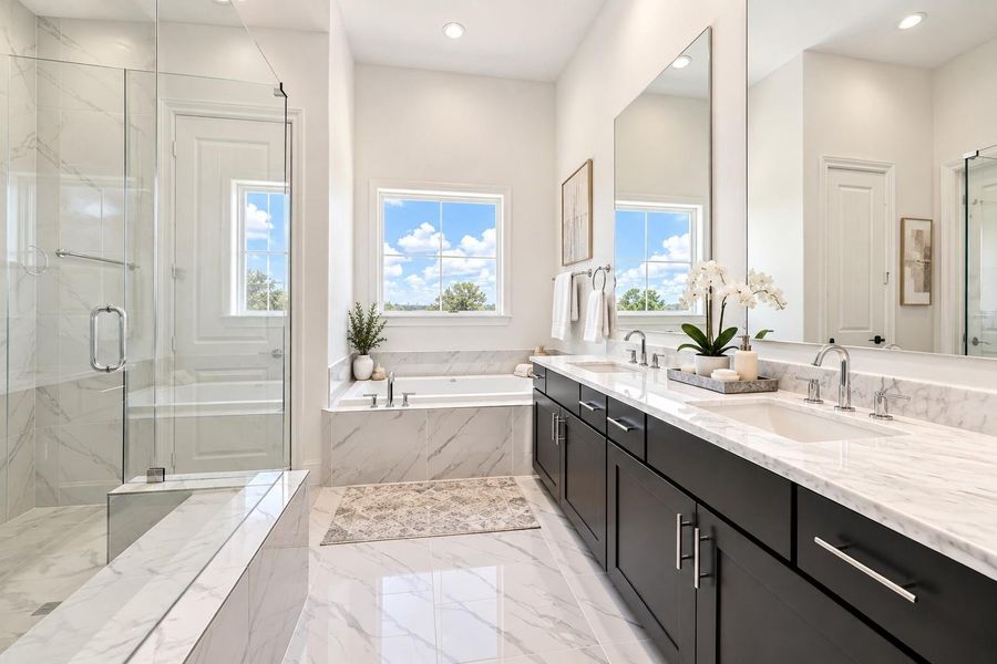 The primary bathroom offers a separate shower and oversized tub with still more natural light.