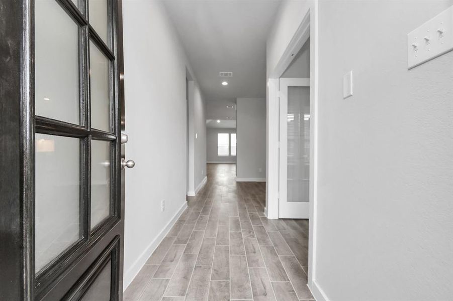 As you step into the threshold of this luxurious home, you'll soon be welcomed by an elegant glass door. Inside, soaring ceilings amplify the spaciousness, while the refined wood-look tile flooring and oversized baseboards exude sophistication and charm. Sample photo of completed home with similar floor plan. Actual colors and selections may vary.