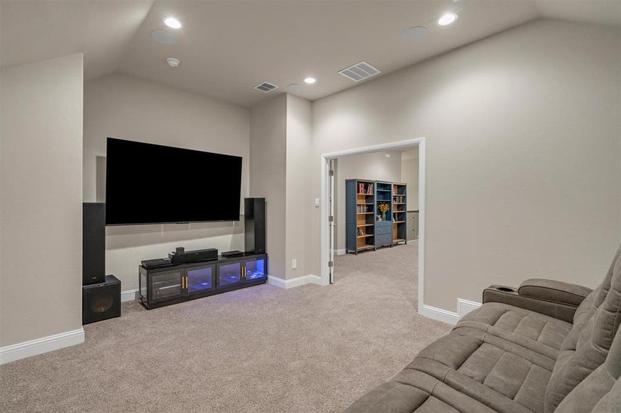 Living area with lofted ceiling, light colored carpet, and recessed lighting