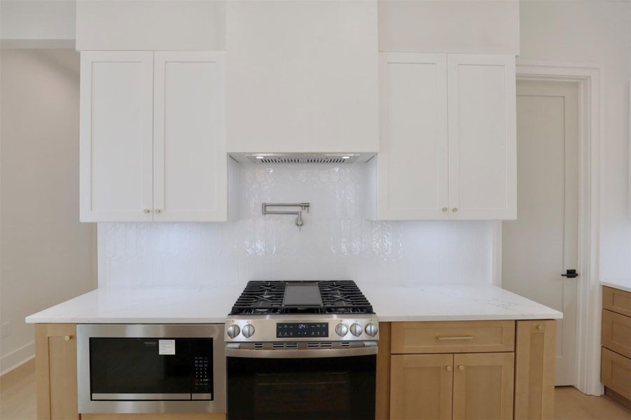 Gas range is complemented by the statement pot filler, Built-in microwave seamlessly are integrated.