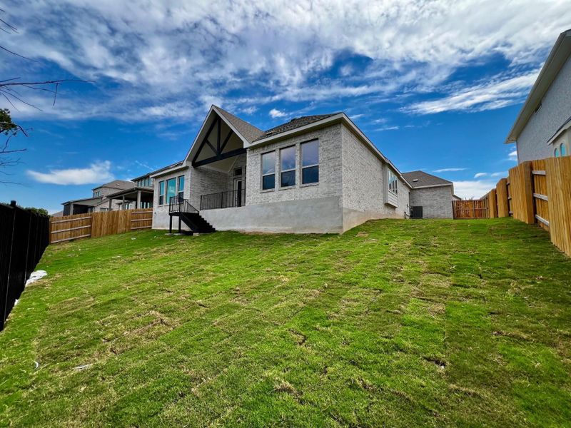 Back of property with a patio, brick siding, a fenced backyard, and stairway Back of property with a patio, brick siding, a fenced backyard, and stairway