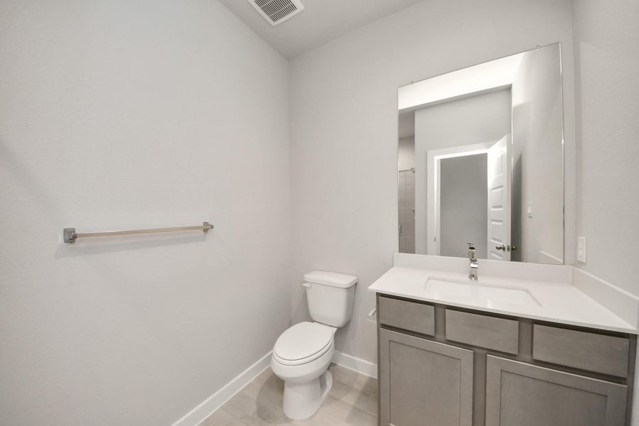 Secondary bath features tile flooring, walk-in shower with tile surround, light stained wood cabinets, beautiful light countertop. Sample photo of completed home with similar floor plan. Actual colors and selections may vary. Secondary bath features tile flooring, walk-in shower with tile surround, light stained wood cabinets, beautiful light countertop. Sample photo of completed home with similar floor plan. Actual colors and selections may vary.