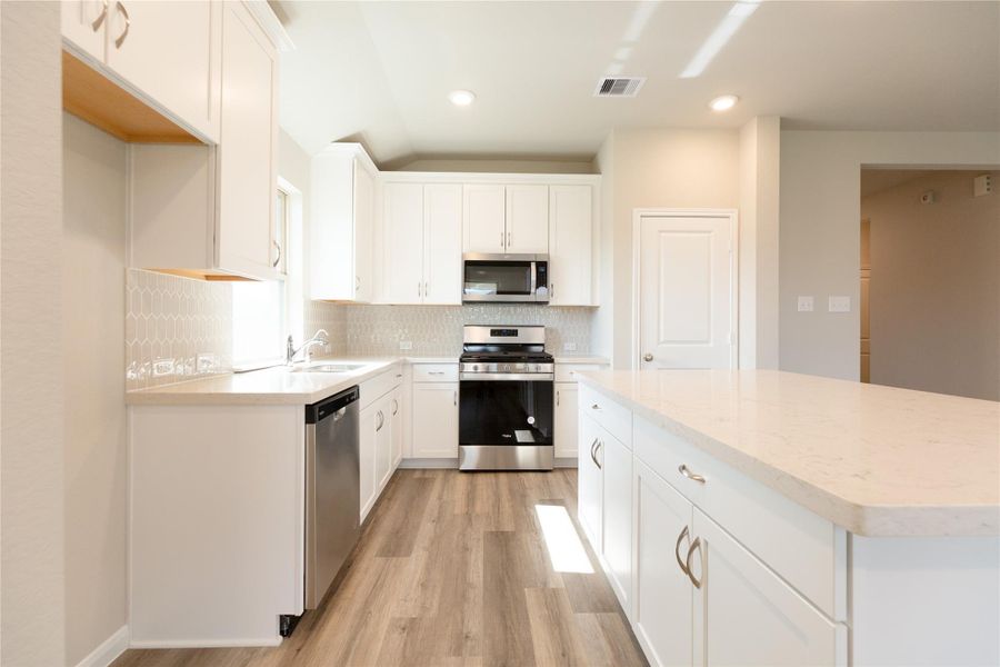 This kitchen is by far any chef’s dream! This spacious kitchen features high ceilings, light stained wood cabinets, granite countertop, SS appliances, modern tile backsplash, recessed lighting, extended counter space, granite kitchen island, and space for breakfast bar, and a walk-in pantry all overlooking your huge family room. Sample photo of completed home with similar floor plan. Actual colors and selections may vary.