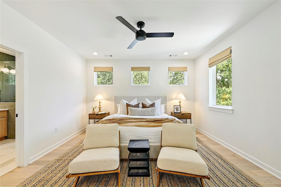 Spacious primary suite with bamboo roman shades and treehouse views through clerestory windows. Spacious primary suite with bamboo roman shades and treehouse views through clerestory windows.