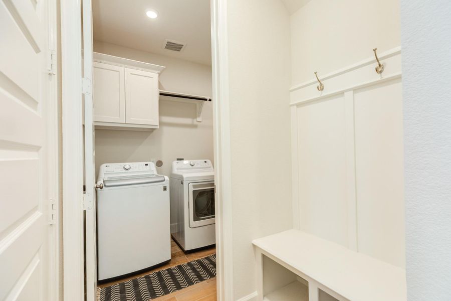 Laundry room featuring a convenient clothes rack and ample storage cabinets, situated directly adjacent to the mudroom Laundry room featuring a convenient clothes rack and ample storage cabinets, situated directly adjacent to the mudroom