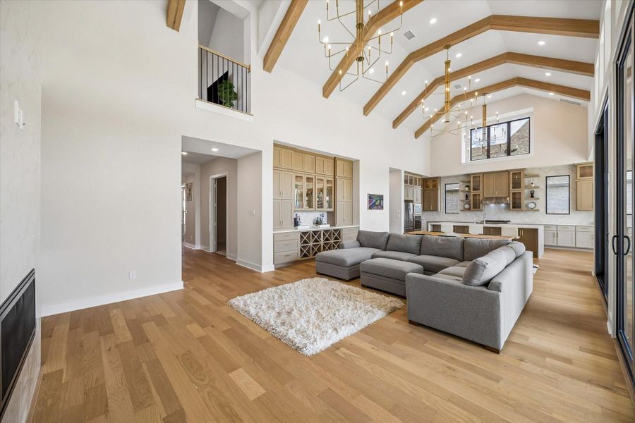 A WIDE VIEW OF THE FAMILY ROOM HIGHLIGHTS THE VAULTED CEILING, EXPOSED WOOD BEAMS, AND OPEN SIGHTLINES TO THE KITCHEN. LARGE GLASS DOORS AND HIGH WINDOWS FILL THE SPACE WITH LIGHT. A WIDE VIEW OF THE FAMILY ROOM HIGHLIGHTS THE VAULTED CEILING, EXPOSED WOOD BEAMS, AND OPEN SIGHTLINES TO THE KITCHEN. LARGE GLASS DOORS AND HIGH WINDOWS FILL THE SPACE WITH LIGHT.