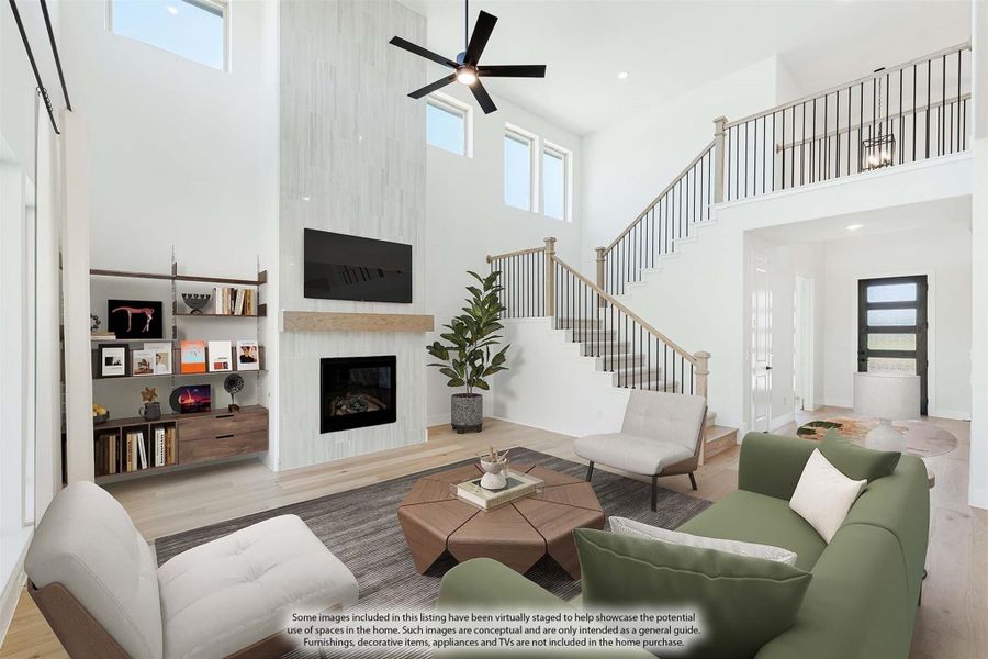Open living room with two-story ceiling, fireplace, built-in shelves, and staircase to upper level