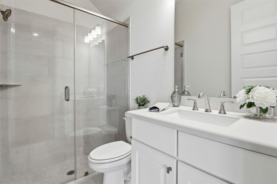 Private bath for secondary bedroom features a walk-in shower.