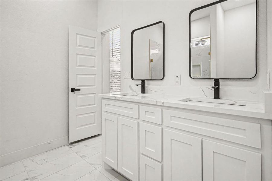 Fabulous contemporary bathroom with double vanity, light marble tile floors, contemporary dimmable lighted mirrors.