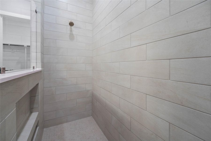 A built-in shelf area is integrated into the lower half of the partition wall, providing convenient storage for bath products.