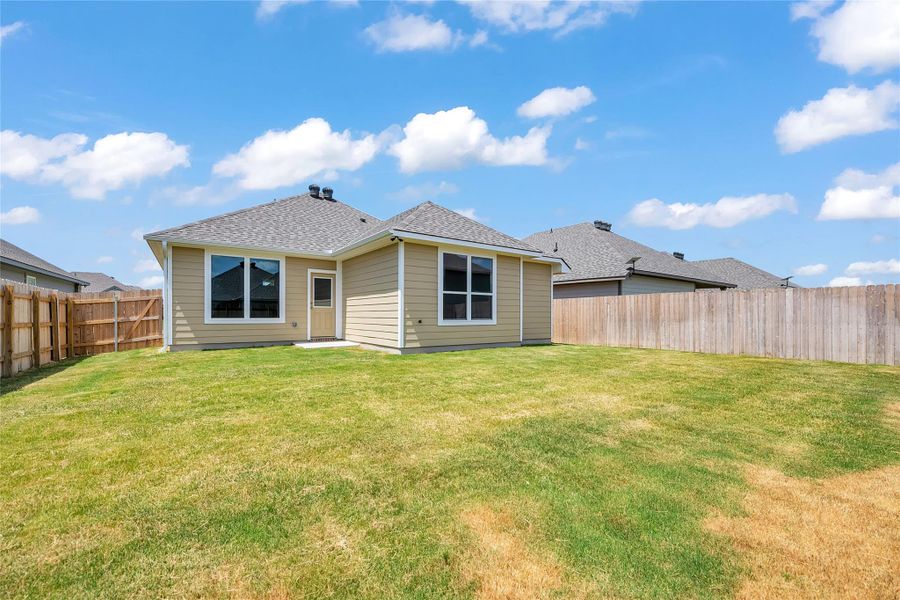 Back of house with a fenced backyard, a shingled roof, and a patio area Back of house with a fenced backyard, a shingled roof, and a patio area