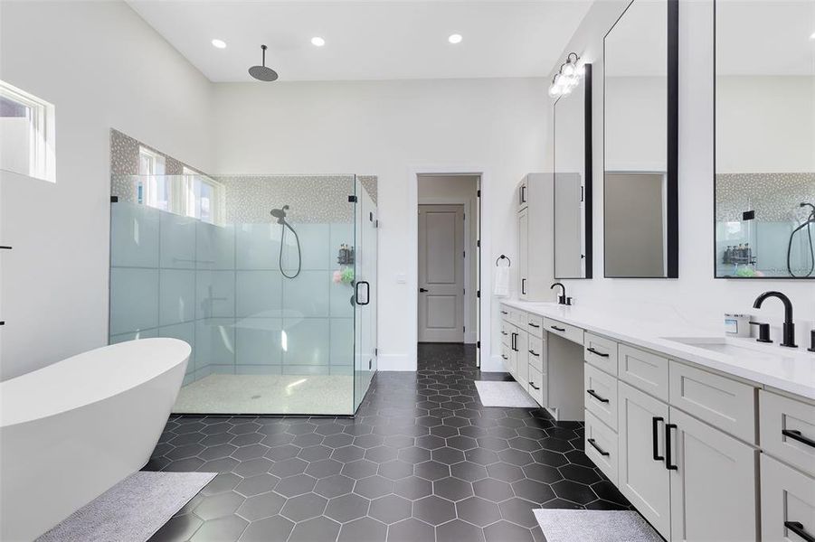 The spa-like en suite bath includes a dual quartz vanity, a stand-alone soaking tub, and a frameless glass shower with a rainfall showerhead. Three