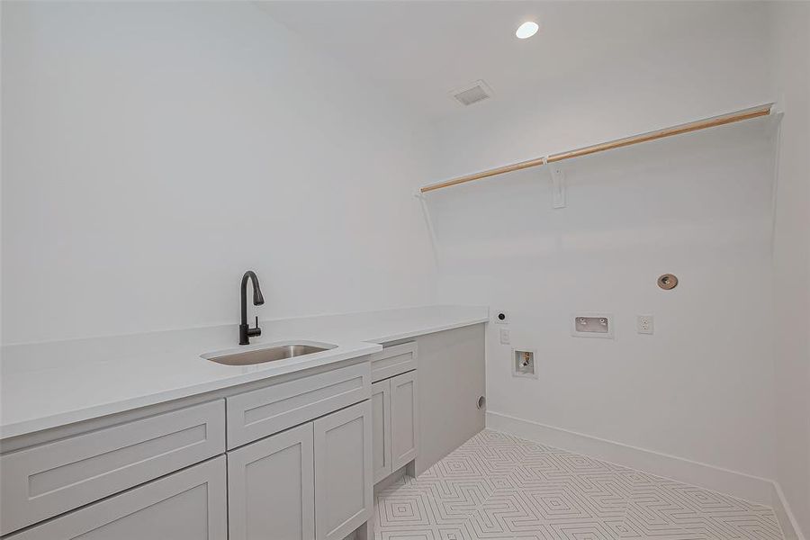 Laundry room with utility sink and built in cabinets