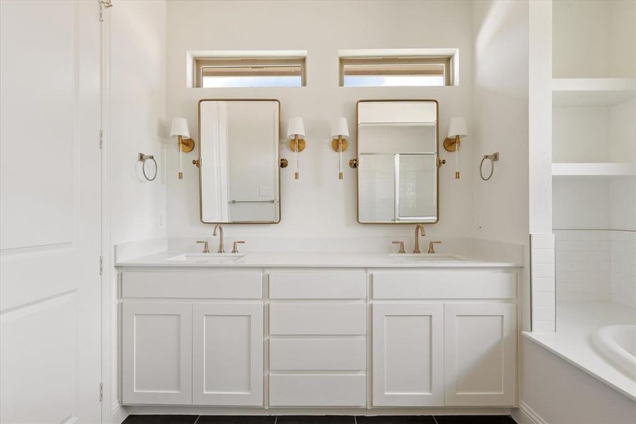 Bathroom with a tub to relax in, vanity, and tile patterned floors