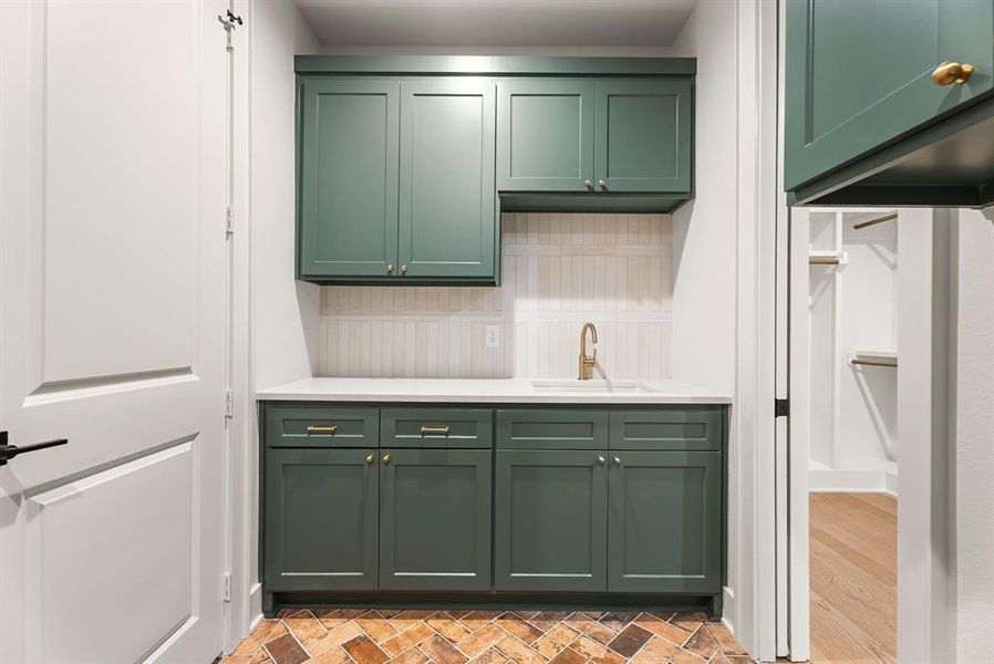 Kitchen featuring green cabinets and a sink