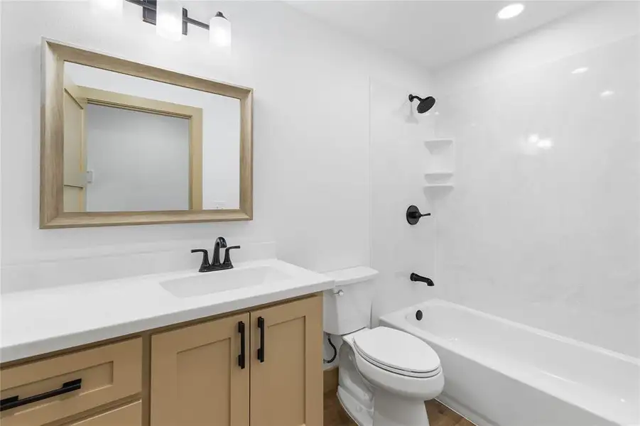 Full bath featuring shower / bathtub combination, vanity, and wood finished floors