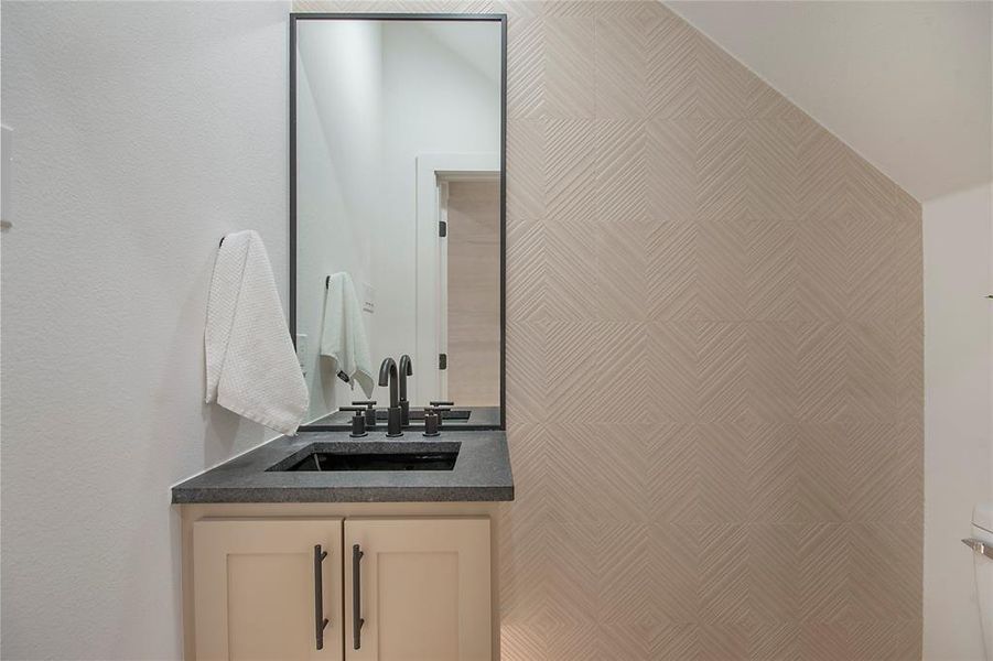 Bathroom with vanity and a textured wall