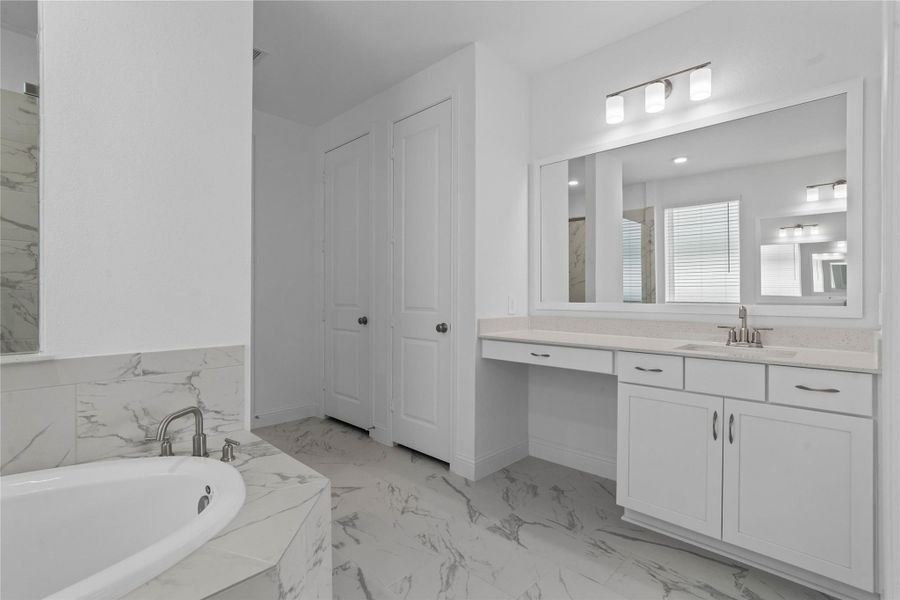 Modern primary bath features dual vanities with sleek cabinetry, quartz countertop, and crisp brushed nickel fixtures for a truly contemporary feel.